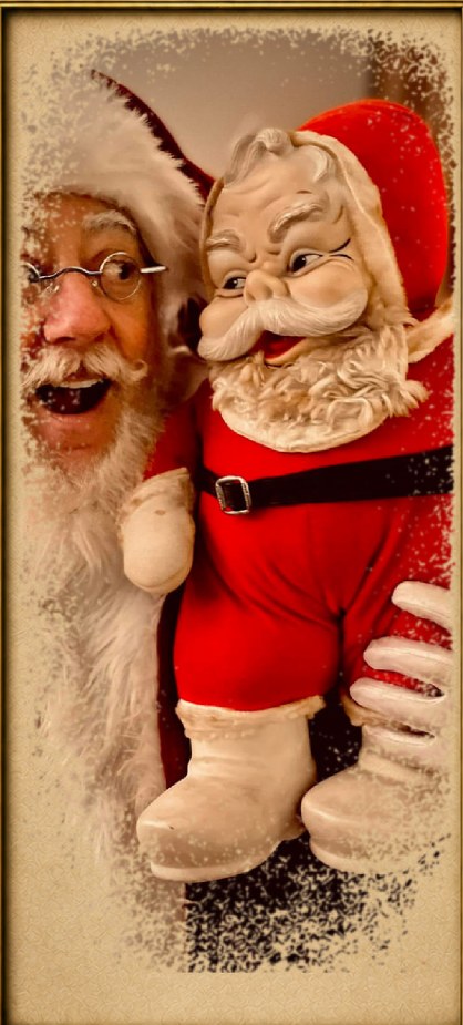 Santa James smiling while holding a vintage Santa doll.