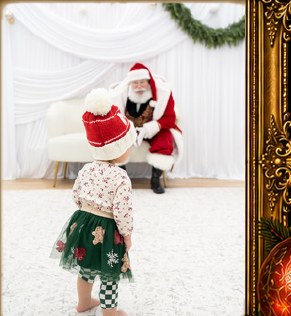A young child approaching Santa James during a Christmas visit.